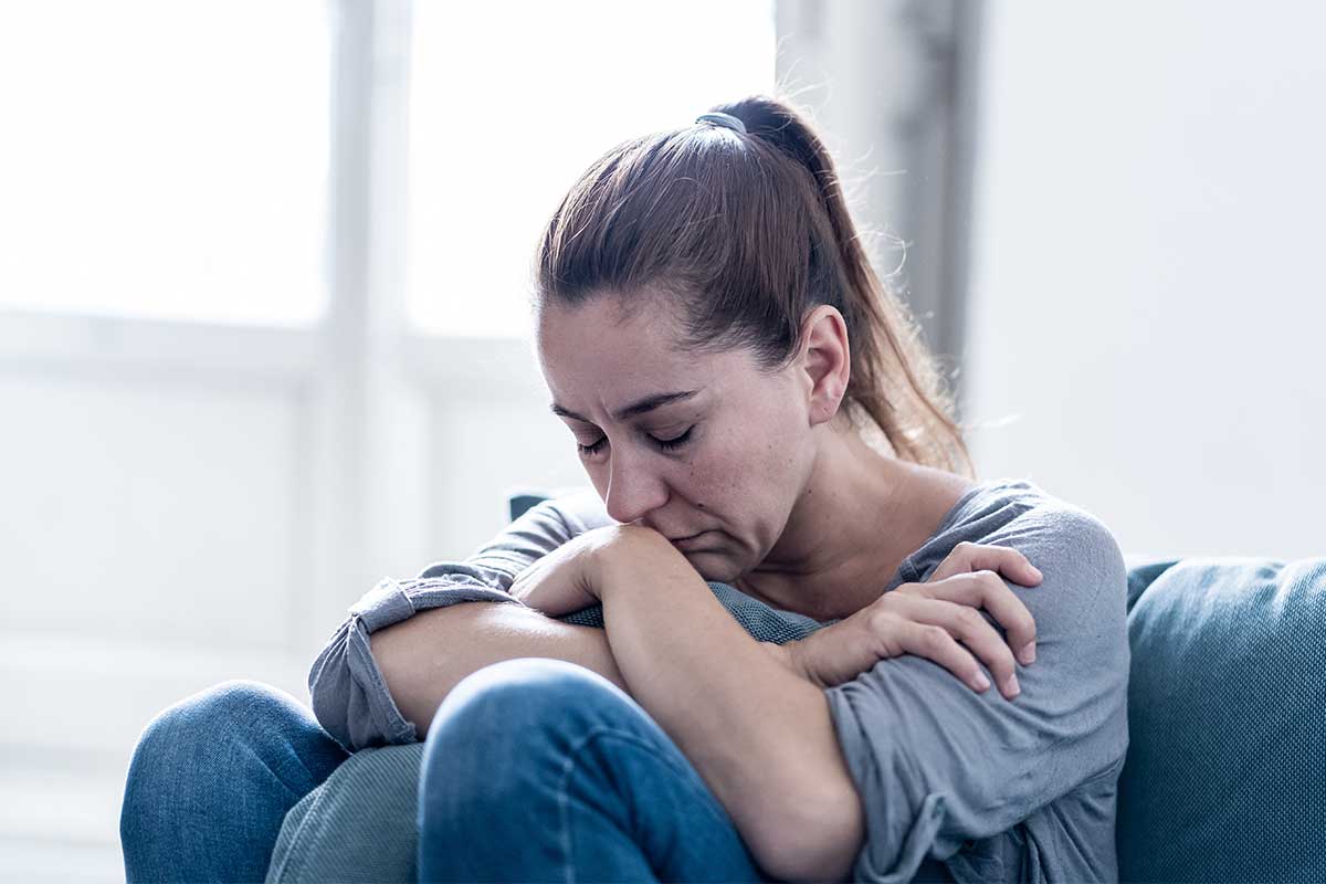 woman hugging a pillow with arms crossed, effects of heroin on the body